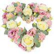 A gentle, heart-shaped funeral tribute fills the image, composed of densely packed pastel flowers that glow softly against a crisp white background. The heart itself is defined by an artful mix of creamy yellow and ivory roses, pale pink carnations, deeper pink lisianthus, and cool eucalyptus foliage, all placed closely together to create a rich, cushion-like effect. The roses draw the eye first, with their classic spirals of velvety petals opening in calm, rounded blooms. Around them, the carnations contribute a textured, frilled surface, their light pink tones suggesting tenderness, comfort, and quiet affection. Threaded throughout, lisianthus blooms in richer shades of mauve and magenta-pink add dimension and a modern touch, their lightly flared petals creating subtle shadows and highlights. Small yellow-green buds appear here and there, adding an uplifting note of freshness. Silvery-green eucalyptus leaves weave between the flowers, their rounded shapes framing the heart's contour and bringing a cool, serene balance to the warm pastels, much like the soft marine light and riverside greenery around Leamouth's wharves. The overall appearance is lush and carefully balanced, with each bloom contributing to a feeling of harmony and gentle remembrance. This heart-shaped arrangement would be a thoughtful choice for funeral services, memorial ceremonies, or scattering-of-ashes gatherings in Leamouth, offering families a calm, beautiful expression of love and sympathy. It feels like a quiet promise that, even in loss, there remains a circle of care, memory, and enduring connection.